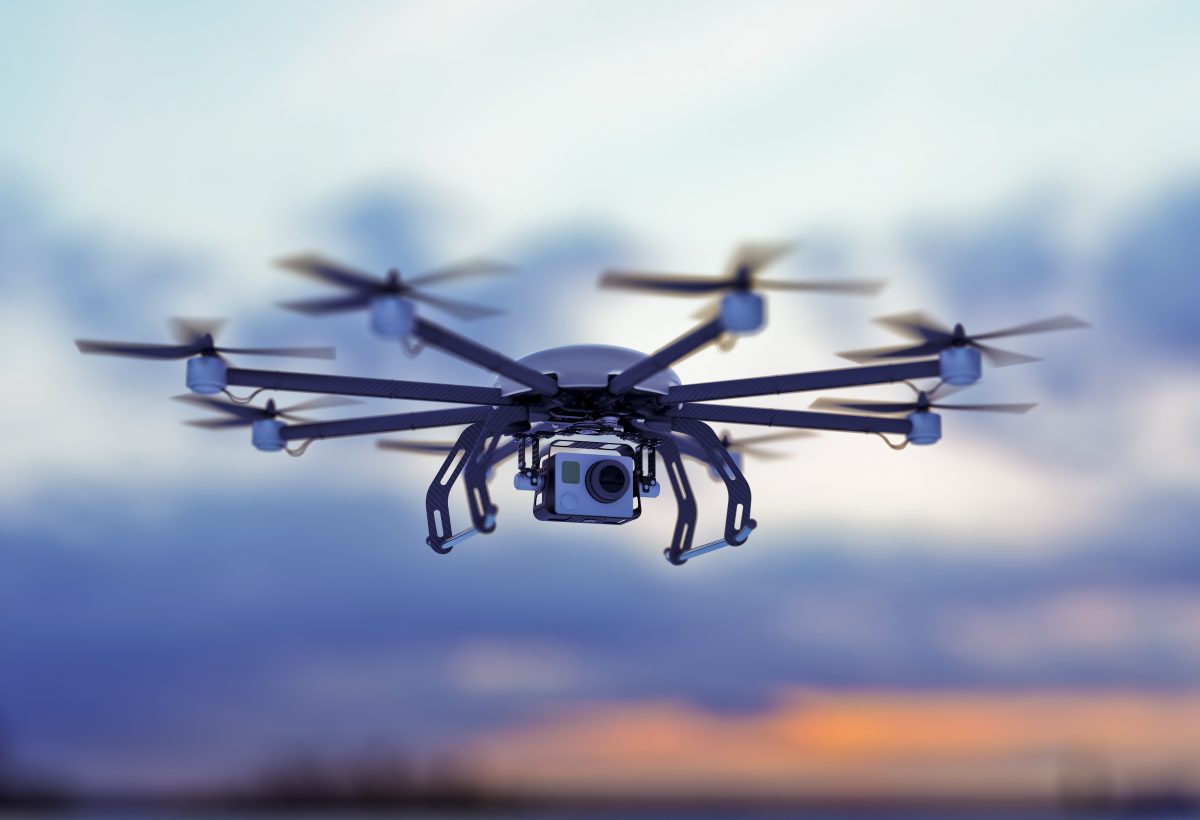 a drone flying in a cloudy sky where the sun goes down